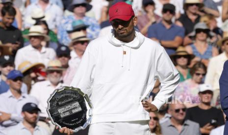  Petenis Australia Nick Kyrgios dengan trofi runner-up setelah final tunggal putra melawan petenis Serbia Novak Djokovic pada hari keempat belas kejuaraan tenis Wimbledon di London, Ahad (10/7/2022)..