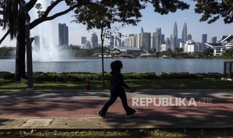 Pejalan kaki berjalan dengan latarbelakang  gedung-gedung bertingkat di Kuala Lumpur, Malaysia. Malaysia berpotensi meraih status negara berpenghasilan tinggi pada 2028, (ilustrasi)