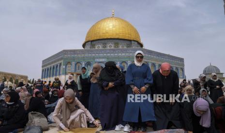 Wanita Palestina berdoa selama bulan suci Islam Ramadhan di depan kuil Dome of the Rock di kompleks Masjid Al Aqsa di kota tua Yerusalem, Jumat, 8 April 2022. Serangan Pemukim ke Masjid Al Aqsa Meningkat