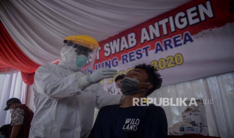 Warga yang hendak berlibur melakukan Rapid Test Antigen Covid-19 yang disediakan oleh Jasa Marga di Rest Area KM 57, Karawang, Jawa Barat, Kamis (24/12). Warga yang tidak memiliki surat keterangan non reaktif Covid-19 diminta untuk melakukan Rapid Test Antigen ditempat yang sudah disediakan. Rapid Test Antigen tersebut dilakukan untuk melacak lonjakan kasus positif disaat libur Natal dan Tahun Baru 2020. Republika/Thoudy Badai