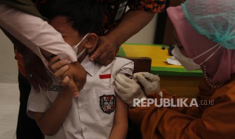 Petugas medis menyuntikkan vaksin COVID-19 kepada siswa berusia 6-11 tahun di SD Negeri Kleco, Solo, Jawa Tengah, Selasa (21/12/2021). Vaksinasi anak menargetkan sasaran sebanyak 26,5 juta anak berdasarkan data sensus penduduk 2020. 