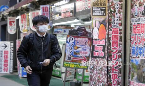 Seorang pejalan kaki melewati toko ritel di Tokyo, Jepang, 10 Januari 2023 (ilustrasi). Harga makanan akan terus melonjak di Jepang dalam empat bulan pertama tahun ini.