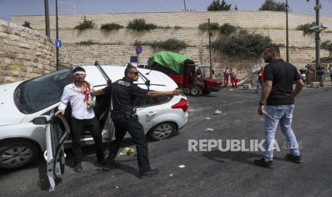 PM Skotlandia Kecam Serangan Israel di Al Aqsa. Foto: Seorang petugas polisi Israel melindungi seorang pengemudi Yahudi yang diserang oleh pengunjuk rasa Palestina di dekat Kota Tua Yerusalem, Senin 10 Mei 2021. 