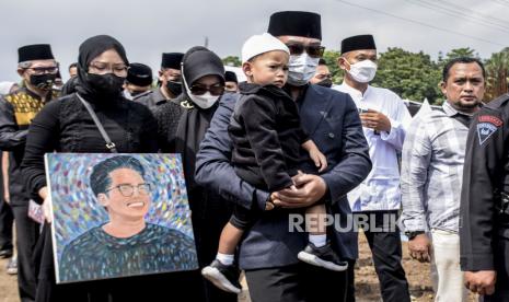 Gubernur Jawa Barat Ridwan Kamil (ketiga kanan) menggendong putranya Arkana Aidan Misbach bersama istrinya Atalia Praratya (kedua kiri) dan putrinya Camillia Laetitia Azzahra (kiri) mengikuti prosesi pemakaman putra sulungnya Emmeril Khan Mumtadz di Islamic Centre Baitul Ridwan, Cimaung, Kabupaten Bandung, Senin (13/6/2022). Putra sulung Gubernur Jawa Barat Ridwan Kamil tersebut meninggal terbawa arus di Sungai Aare, Kota Bern, Swiss pada 26 Mei 2022 dan jenazahnya ditemukan di Bendungan Engehalde, Kota Bern, Swiss pada 8 Juni 2022. Foto: Republika/Abdan Syakura