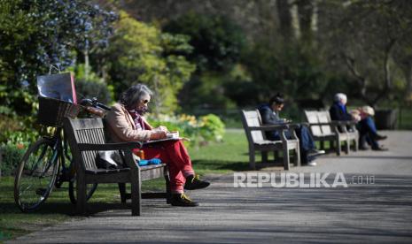 Orang-orang menjaga jarak di bangku di Taman St Jame, London Inggris, Selassa (24/3). Menteri Keuangan Inggris Rishi Sunak menyebut produk domestik bruto (PDB) negaranya bisa anjlok hingga 30 persen akibat pandemi Covid-19. Penurunan tersebut diprediksi bakal terjadi antara April hingga Juni mendatang. 