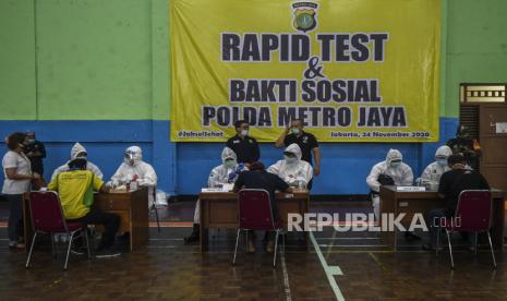 Tenaga medis melakukan tes cepat (rapid test) COVID-19 terhadap warga di Gelanggang Olahraga Tebet, Jakarta, Senin (23/11/2020). Polda Metro Jaya menyelenggarakan bakti sosial penyemprotan cairan disinfektan dan tes cepat atau rapid test COVID-19 karena adanya temuan kasus terkonfirmasi positif COVID-19 dari jemaah Maulid Nabi Muhammad SAW yang diselenggarakan di kawasan Tebet.