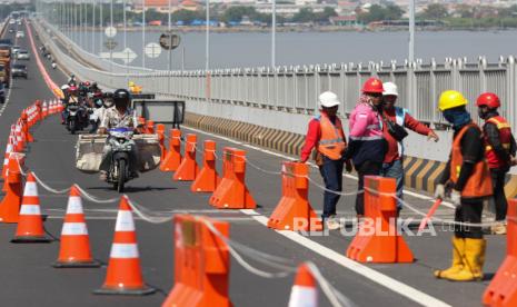 Sejumlah pengendara motor melintas di lajur kendaraan roda empat yang sudah dibatasi dengan 