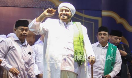 Pendakwah Habib Syech bin Abdul Qodir Assegaf (tengah) didampingi Wakil Ketua Pengurus Cabang Nahdlatul Ulama Kota Kediri Nur Muhyar (kiri) menyapa umat saat memimpin sholawat di Stadion Brawijaya, Kota Kediri, Jawa Timur, Sabtu (21/10/2023). Kegiatan yang dihadiri ribuat umat Islam bertajuk Kediri Bersholawat tersebut guna memperingati HUT ke-1.144 Kota Kediri. 