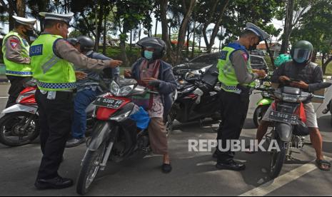 Sejumlah anggota Polantas memeriksa lembar pajak kendaraan bermotor (PKB) saat melakukan razia di Serang, Banten, Jumat (25/11/2022). Kendaraan yang belum membayar pajak selama dua tahun berturut-turut akan dihapus data registrasinya.