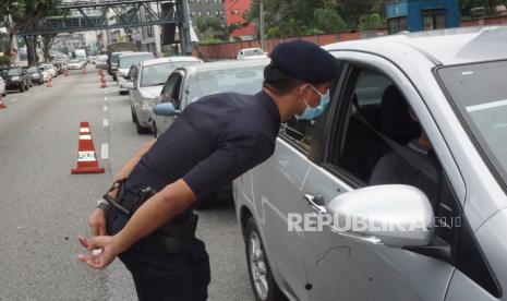 Petugas Kepolisian Diraja Malaysia (PDRM) melakukan pemeriksaan terhadap pengendara mobil yang masuk ke Kuala Lumpur di depan Kantor Polisi Tun HS Lee Jalan Loke Yew Kuala Lumpur, Kamis (19/3/2020). (Antara/Agus Setiawan)