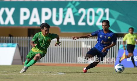 Pesepak bola Sumatera Utara Faisal Ramdoni (kiri) berusaha melewati pesepak bola Aceh Muharrir (kanan) pada babak enam besar sepak bola putra PON Papua di Stadion Mandala, Kota Jayapura, Papua, Jumat (8/10/2021). Tim sepak bola putra Aceh menang atas tim sepak bola putra Sumatera Utara dengan skor akhir 2-1. 