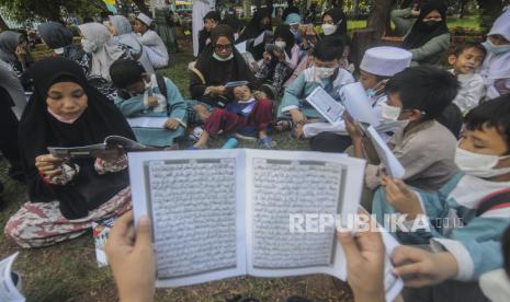  Pesantren Ramah Anak Harus Diwujudkan Bertahap dan Berkelanjutan. Foto ilustrasi:  Sejumlah umat Islam membaca Al-Quran sambil menunggu waktu berbuka puasa di depan Masjid Raya Jakarta Islamic Center, Jakarta, Senin (18/4/2022).  Masjid Raya Jakarta Islamic Center melaksanakan kegiatan ngabuburit sambil khataman Al-Quran yang melibatkan 500 santri sari Pondok Pesantren dan warga sekitar dalam rangka menyambut 17 Ramadhan atau malam Nuzulul Quran. Republika/Putra M. Akbar