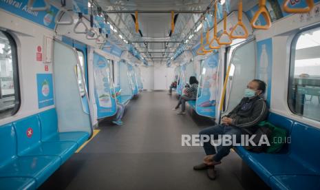 Penumpang menggunakan masker saat menaiki MRT (ilustrasi).