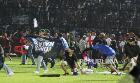 Suporter Arema FC memasuki lapangan setelah tim yang didukungnya kalah dari Persebaya dalam pertandingan sepak bola BRI Liga 1 di Stadion Kanjuruhan, Malang, Sabtu (1/10/2022).