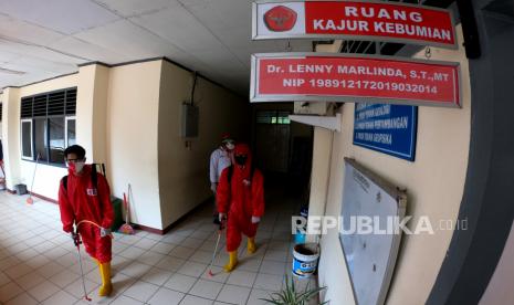 Relawan Palang Merah Indonesia (PMI) Provinsi Jambi berjalan keluar usai menyemprotkan cairan disinfektan di kawasan Fakultas Sains dan Teknologi, Universitas Jambi, Jambi, Jumat (25/9/2020). Universitas Jambi di Mendalo Darat, Muarojambi resmi ditutup untuk aktivitas akademik dan administrasi perkantoran mulai 25-27 September 2020 menyusul seorang dosennya terkonfirmasi positif COVID-19 berdasarkan hasil tes usap. 