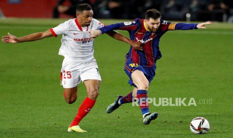 Penyerang FC Barcelona Lionel Messi (kanan) bersaing memperebutkan bola dengan gelandang Sevilla Fernando Reges (kiri) pada pertandingan leg kedua semifinal Piala Raja Spanyol antara FC Barcelona dan Sevilla CF yang diadakan di stadion Camp Nou, di Barcelona, ??Spanyol, 03 Maret 2021.