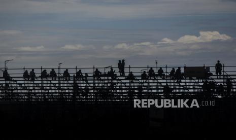 Sejumlah warga menonton pertandingan World SSP Race 1 di Pertamina Mandalika International Street Circuit, Lombok Tengah, Nusa Tenggara Barat, Sabtu (20/11). Pada pertandingan tersebut pebalap asal Italia Raffaele De Rosa meraih posisi pertama mengalahkan juara dunia Dominique Aergerter. Republika/Putra M. Akbar