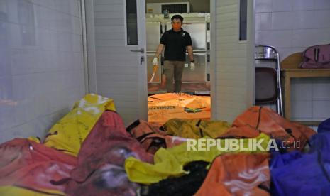  Seorang anggota tim forensik polisi berdiri di dekat kantong mayat yang berisi mayat para korban kebakaran penjara di kamar mayat rumah sakit setempat di Tangerang  Rabu, 8 September 2021. Api besar berkobar melalui sebuah tempat yang penuh sesak penjara dekat ibukota Indonesia Rabu pagi, menewaskan sejumlah narapidana.