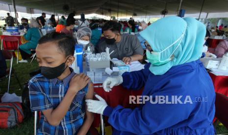 Petugas menyuntikkan vaksin COVID-19 kepada seorang anak di Lapangan Thor, Surabaya, Jawa Timur, Kamis (30/9/2021). Vaksinasi COVID-19 yang diinisiasi Koarmada II dalam rangka percepatan penanganan COVID-19 dan pemulihan ekonomi nasional tersebut menyiapkan 30.000 dosis vaksin COVID-19 setiap harinya dan berlangsung selama dua hari. 