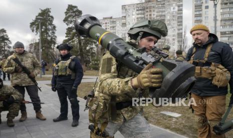  Seorang anggota Pasukan Pertahanan Teritorial Ukraina memegang senjata anti-tank NLAW, di pinggiran Kyiv, Ukraina, Rabu, 9 Maret 2022. Pihak berwenang mengumumkan gencatan senjata baru pada hari Rabu untuk memungkinkan warga sipil melarikan diri dari kota-kota di sekitar ibu kota, Kyiv, saat serta kota-kota selatan Mariupol, Enerhodar dan Volnovakha, Izyum di timur dan Sumy di timur laut. Upaya sebelumnya untuk membangun koridor evakuasi yang aman sebagian besar gagal karena serangan oleh pasukan Rusia.