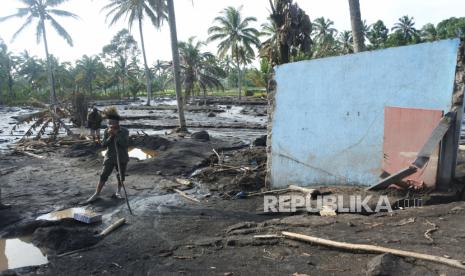 Bupati: Wilayah Terdampak Semeru Bukan untuk Tontonan. Foto: Seorang warga berada di samping rumah saudarannya yang hancur dan tertimbun material Gunung Semeru di Kampung Renteng, Desa Sumberwuluh, Candipuro, Lumajang, Jawa Timur, Kamis (9/12/2021). Hari keenam penanggulangan bencana Gunung Semeru sejumlah warga terdampak awan panas guguran Gunung Semeru masih mencari keluarganya yang belum ketemu. 