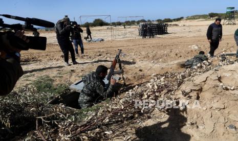 Seorang aktor berpakaian sebagai militan Hamas merangkak keluar dari terowongan saat kru dari saluran satelit al-Aqsa yang dikelola Hamas syuting untuk serial 30 episode, berjudul Fist of the Free, di Beit Lahiya, Jalur Gaza utara, Kamis , 3 Februari 2022. 