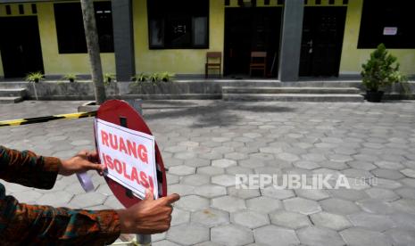 Petugas memasang tanda peringatan kawasan isolasi mandiri untuk pasien Covid-19 di Balai Desa Merdikorejo, Tempel, Sleman, Rabu (16/12). Di halaman balai desa dibuatkan kawasan khusus untuk warga yang positif Covid-19. Sekarang tinggal dua warga yang masih tinggal di kawasan isolasi ini. Untuk makanan, selain dari pihak desa, warga juga ikut memberikan bantuan. Dan untuk kondisi pasien dipantau oleh Puskesmas Tempel.