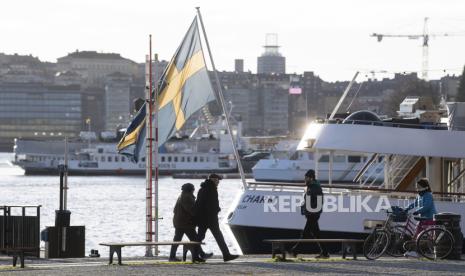  Orang berjalan-jalan dalam cuaca dingin tapi cerah di sepanjang sisi dermaga Standvagen di Stockholm, Swedia, 20 November 2020. Turki Panggil Utusan Swedia atas Rencana Penodaan Alquran