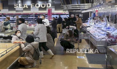  Pengunjung supermarket membungkuk saat gempa di Toyama, Jepang, Senin (1/1/2024). Jepang mengeluarkan peringatan waspada tsunami dan meminta masyarakat menghindari area pantai.