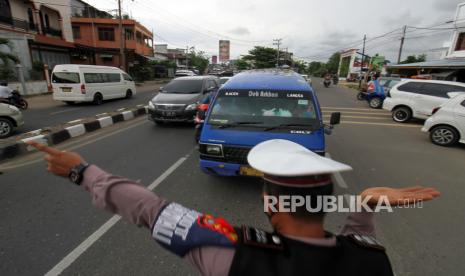 Petugas gabungan mengarahkan mobil angkutan umum untuk putar balik di pos penyekatan mudik (ilustrasi) 