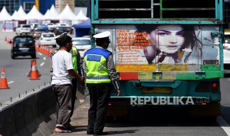 Petugas kepolisian memeriksa bak truk di tol Jakarta-Cikampek, Cikarang Barat, Jawa Barat, Kamis (7/5/2020). Pemerintah menyatakan masyarakat Indonesia tetap dilarang mudik, tapi ada pengecualian bagi ASN, prajurit TNI dan Polri, pegawai BUMN, lembaga usaha, dan LSM yang berhubungan dengan percepatan penanganan COVID-19 serta masyarakat yang keluarganya meninggal atau keluarga sakit, repatriasi, pekerja migran Indonesia, TKI, dan pelajar atau mahasiswa yang akan kembali ke tanah air