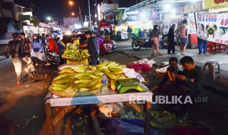 Pedagang jagung melayani pembeli di Jalan Panorama, Kecamatan Lembang, Kabupaten Bandung Barat, Kamis (31/12). Suasana jelang pergantian tahun di kawasan Lembang sepi, seiring adanya surat edaran Pemkab Bandung Barat yang melarang kegiatan perayaan saat malam pergantian tahun 2021 karena Kabupaten Bandung Barat (KBB) masih masuk zona tinggi penyebaran Covid-19 atau zona merah.