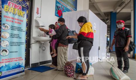 Penumpang bus melewati bilik disinfektan dan mencuci tangan saat turun di Terminal Tirtonadi, Solo, Jawa Tengah, Rabu (1/4). Hingga saat ini, pemerintah masih mengimbau masyarakat agar tidak melakukan mudik padahal sudah memasuki status darurat virus korona atau Covid-19. Ketua Umum Transportasi Indonesia (MTI) Agus Taufik Mulyono mengatakan selain regulasi mengikat larangan mudik, pemerintah harus menyediakan kompensasi. 