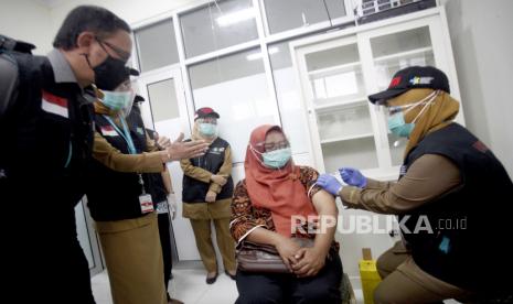 Petugas medis memberikan vaksin COVID-19 disaksikan Wali Kota Bogor Bima Arya (kiri) pada simulasi vaksinasi COVID-19 di Puskesamas Tanah Sareal, Kota Bogor, Jawa Barat, Rabu (18/11/2020). Menteri Kesehatan (Menkes) Terawan Agus Putranto mengatakan, pemerintah menargetkan imunisasi COVID-19 akan diberikan kepada 67 persen dari 160 juta penduduk berusia 18-59 tahun atau sebanyak 107,2 juta orang, pemberian vaksinasi akan dilakukan melalui skema vaksin program dan vaksin mandiri. 