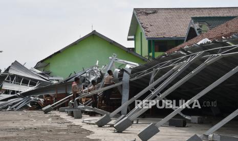 Sejumlah siswa melihat kondisi bangunan tempat parkir yang roboh di SMKN 1 Mejayan akibat bencana puting beliung di Mejayan, Kabupaten Madiun, Jawa Timur, Jumat (1/12/2023). Hujan disertai puting beliung di wilayah tersebut yang terjadi pada Kamis (30/11) mengakibatkan sejumlah bangunan rumah, sekolah, toko, kantor pemerintah, rumah sakit, kandang ternak rusak, serta sejumlah tiang kabel listrik dan pohon roboh. 