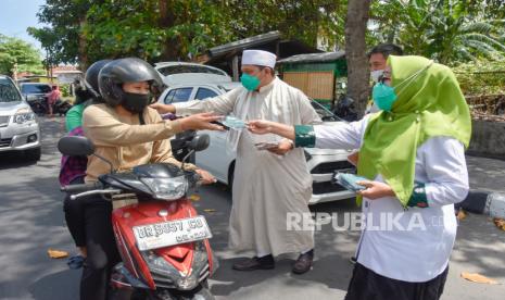 Bakal Pasangan Calon Walikota dan Wakil Walikota Mataram Selly Andayani (kanan) dan TG Abdul Manan (tengah) membagikan masker kepada pengguna jalan saat sosialisasi penerapan protokol kesehatan COVID-19 dalam pelaksanaan Pilkada serentak tahun 2020  di Mataram, NTB, Kamis (10/9/2020). Sosialisasi yang diselenggarakan oleh Polresta Mataram tersebut dihadiri oleh KPU Kota Mataram, Bawaslu, Forkopimda, Bapaslon Walikota dan Wakil Walikota Mataram, tokoh agama serta tokoh adat kota Mataram yang bertujuan untuk upaya meminimalisir potensi kerumunan massa yang tidak mengabaikan protokol kesehatan COVID-19 dalam pelaksanaan tahapan Pilkada serentak 2020. 