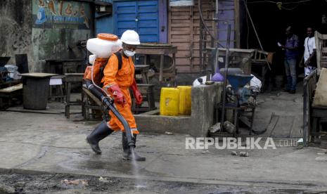 Petugas kesehatan menyemprotkan disinfektan di pasar informal, Lagos, Nigeria, Selasa (31/3).  Kematian misterius di Nigeria memicu penyelidikan kaitan dengan Covid-19. Ilustrasi.