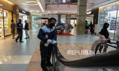 Petugas kebersihan membersihkan pegangan tangan eskalator dengan cairan disinfektan di salah satu pusat perbelanjaan yang ada di Kota Pekanbaru, Riau, Selasa (2/6/2020). Menjelang penerapan tatanan normal baru sejumlah pusat perbelanjaan di daerah tersebut mulai kembali beroperasi dengan tetap menerapkan protokol kesehatan seperti mewajibkan pemakaian masker bagi semua pengunjung, mencuci tangan dan mengukur suhu tubuh sebelum masuk ke pusat perbelanjaan tersebut