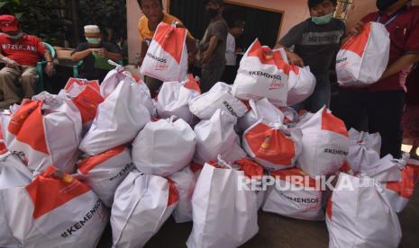 Petugas dibantu warga menurunkan paket sembako yang diberikan Kementerian Sosial (Kemensos) kepada warga yang membutuhkan di kawasan Kebon Baru, Tebet, Jakarta, Rabu (8/4/2020). Kemensos mendistribusikan 200 ribu paket sembako dan makanan siap saji untuk pekerja sektor informal di wilayah zona merah COVID-19