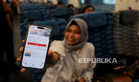 Penumpang menunjukan aplikasi penjualan tiket WHOOSH pada aplikasi mobile saat menaiki kereta cepat WHOOSH di Stasiun Halim, Jakarta, Selasa (17/10/2023). PT KCIC meresmikan aplikasi mobile penjualan tiket bernama WHOOSH Kereta Cepat serta melakukan perjalanan pertama yang mengangkut penumpang berbayar. Pada peresmian tersebut PT KCIC juga memberikan promo bagi penumpang yang membeli tiket melalui aplikasi WHOOSH dengan biaya sebesar Rp150 ribu untuk kelas premium ekonomi dari tanggal 18 Oktober hingga 30 November mendatang sebagai upaya menarik minat masyarakat untuk beralih menggunakan transportasi publik berbasis rel.