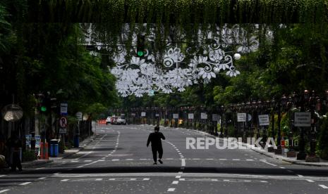 Warga melintas di Jalan Tunjungan yang ditutup, di Surabaya, Jawa Timur, Sabtu (28/3/2020). Penutupan sejumlah jalan di Surabaya tersebut agar terbebas dari segala aktivitas warga dan kendaraan guna mencegah penyebaran Virus Corona (COVID-19)