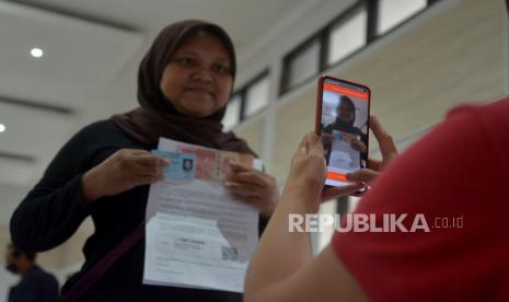 Petugas menyalurkan Bantuan Langsung Tunai (BLT) Bahan Bakar Minyak (BBM) kepada warga di Sasana Krida Karang Taruna (SKKT) Kelurahan Pondok Kopi, Jakarta, Kamis (22/9/2022). Pada kegiatan tersebut sebanyak 771 warga di Kecamatan Duren Sawit menerima manfaat BLT sebesar Rp 300 ribu sebagai kompensasi dari naiknya harga BBM. Republika/Prayogi 