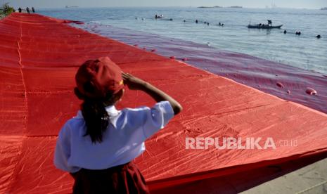 Cinta Tanah Air merupakan sunnah Rasulullah SAW.  Seorang murid SD memberi hormat saat pembentangan bendera merah putih raksasa di Pantai Pulau Lae-Lae, Makassar, Sulawesi Selatan, Senin (17/8/2020). 