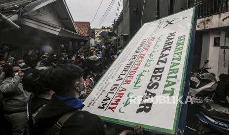 Sejumlah anggota kepolisian dan warga mencopot plang atribut FPI di Jalan Petamburan III, Jakarta, Rabu (30/12). Aparat gabungan dari TNI dan Polri mendatangi kawasan Petamburan III untuk mencabut sejumlah atribut FPI pasca pembubaran organisasi tersebut oleh pemerintah. Republika/Putra M. Akbar