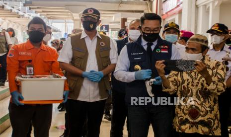 Kepala BNPB sekaligus Kepala Satuan Tugas Nasional Penanganan Covid-19 Doni Monardo (kedua kiri) mendampingi Gubernur Provinsi Jawa Barat Ridwan Kamil (kedua kanan) saat membagikan masker ke calon penumpang kereta di Stasiun Bandung, Bandung, Jawa Barat, Kamis (6/8/2020). Dalam kunjungan kerja tersebut Kepala BNPB melakukan penyerahan bantuan penanganan COVID-19 kepada Pemerintah Provinsi Jawa Barat,  membagikan dan menyosialisaasikan penggunaan masker serta meninjau penerapan protokol kesehatan adaptasi kebiasaan baru. 