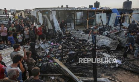 Warga Palestina menyaksikan kehancuran kamp pengungsian di Rafah, Jalur Gaza, usai serangan udara Israel pada Senin (27/5/2024). 