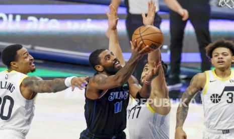 Guard Dallas Mavericks Kyrie Irving (tengah) melakukan layup dalam pertandingan NBA antara melawan Utah Jazz di Texas, AS, 6 Desember 2023. Irving salah satu pemain NBA yang berpuasa tahun ini.