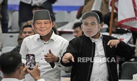 Pendukung memakai topeng capres Prabowo Subianto dan cawapres Gibran Rakabuming Raka di luar kantor KPU, Jalan Imam Bonjol, Jakarta Pusat pada Rabu (25/10/2023).