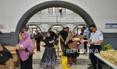 Petugas memberi makanan untuk berbuka kepada penumpang di Stasiun Pasar Senen, Jakarta, Sabtu (6/4/2024). 