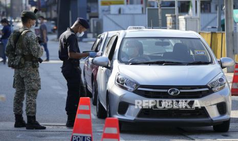 Polisi memeriksa penumpang di kendaraan di penghalang jalan selama hari pertama Full Movement Control Order (MCO) di Kuala Lumpur, Malaysia, Selasa, 1 Juni 2021. 